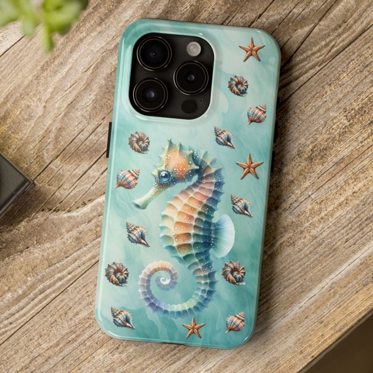 Phone case with seahorse design on a wooden surface