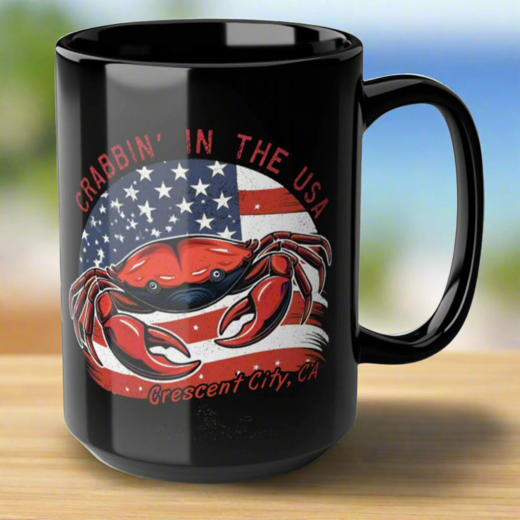 Black mug with a red crab design and American flag with Crescent City, CA underneath.