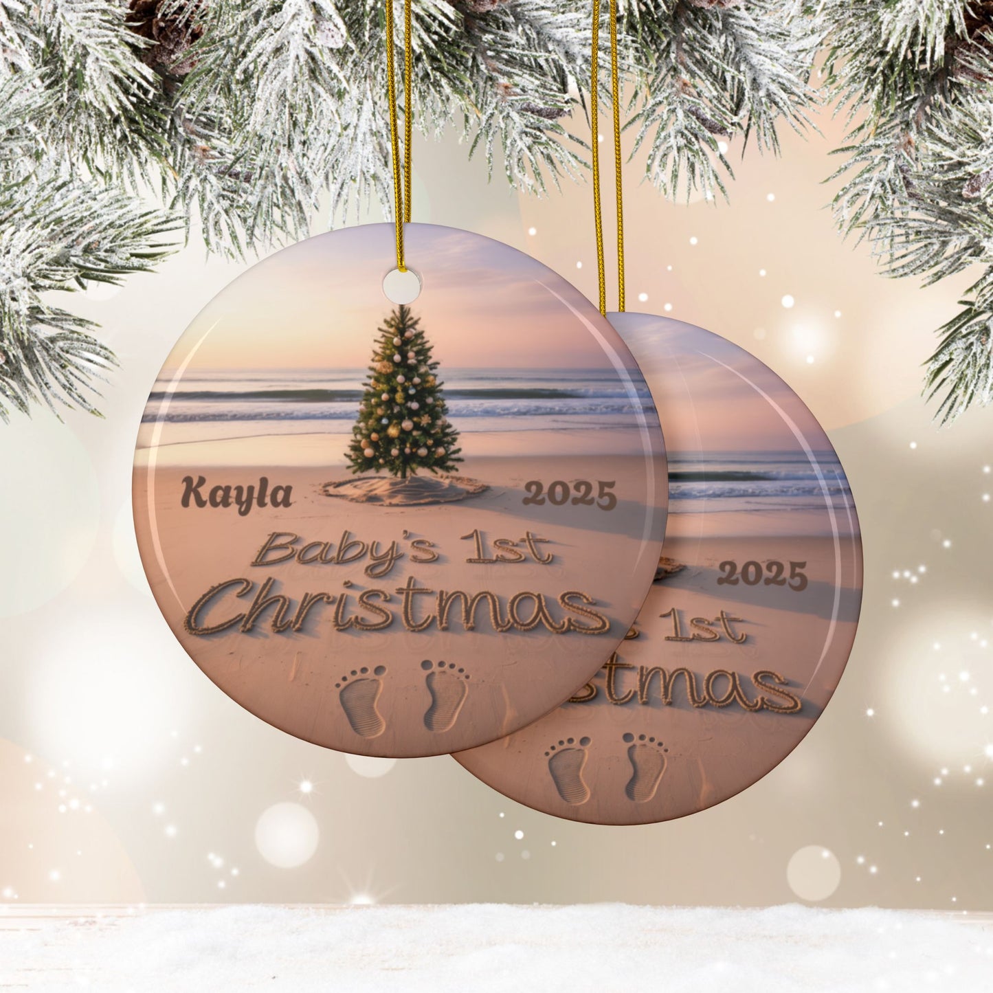 Round Christmas ornament with beach scene and 'Baby's 1st Christmas' text, hanging against a snowy background.