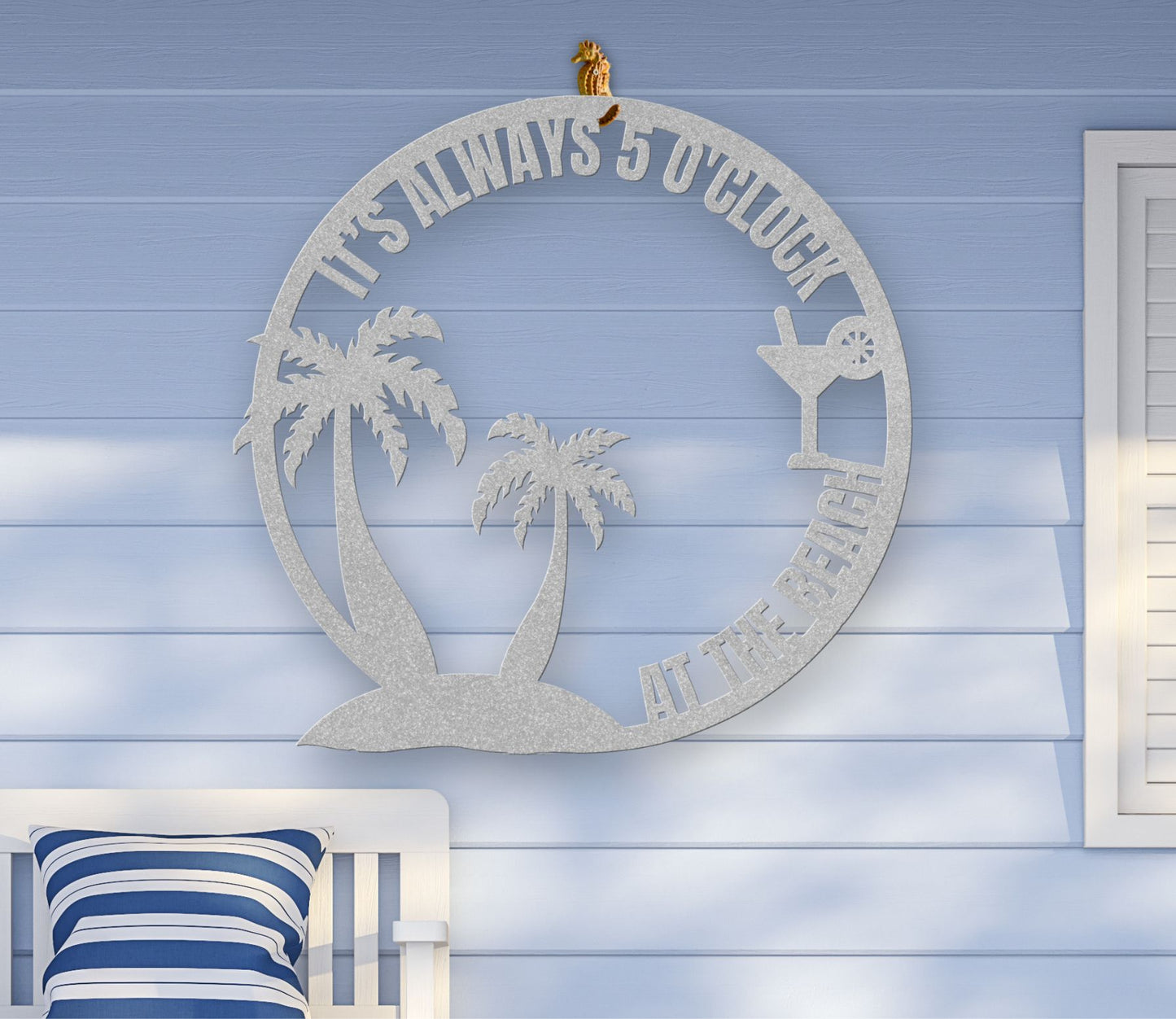 Silver metal wall art featuring palm trees and a cocktail glass with the phrase "It’s 5 0’Clock Beach" in a playful beach theme, available in 6 sizes.