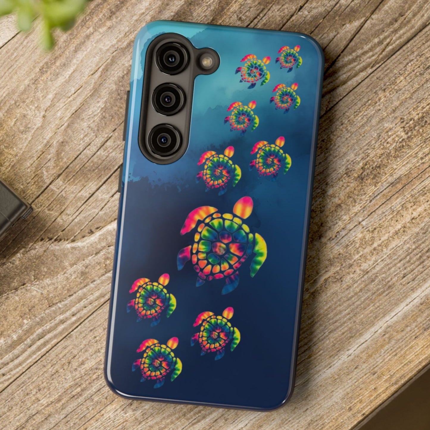 Phone case with colorful spiral design on a wooden surface