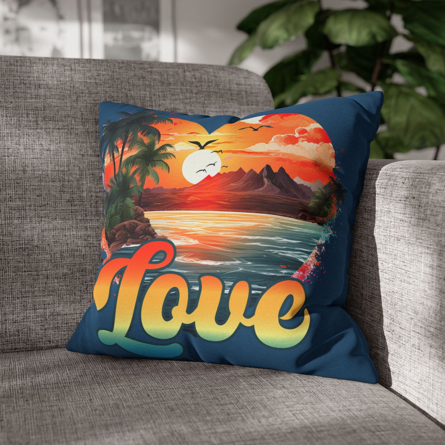 Decorative blue 18" x 18" blue pillow with a sunset heart design and 'love' text on a gray couch.