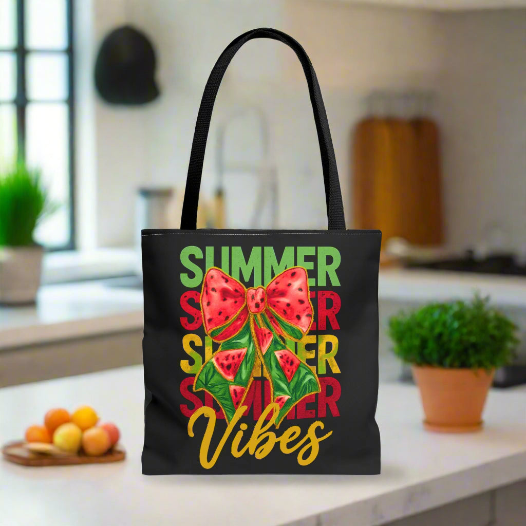 Black tote bag with the word "Summer" repeated in green, red, and yellow, featuring a coquette-style bow, watermelon illustrations, and the word "Vibes" underneath.