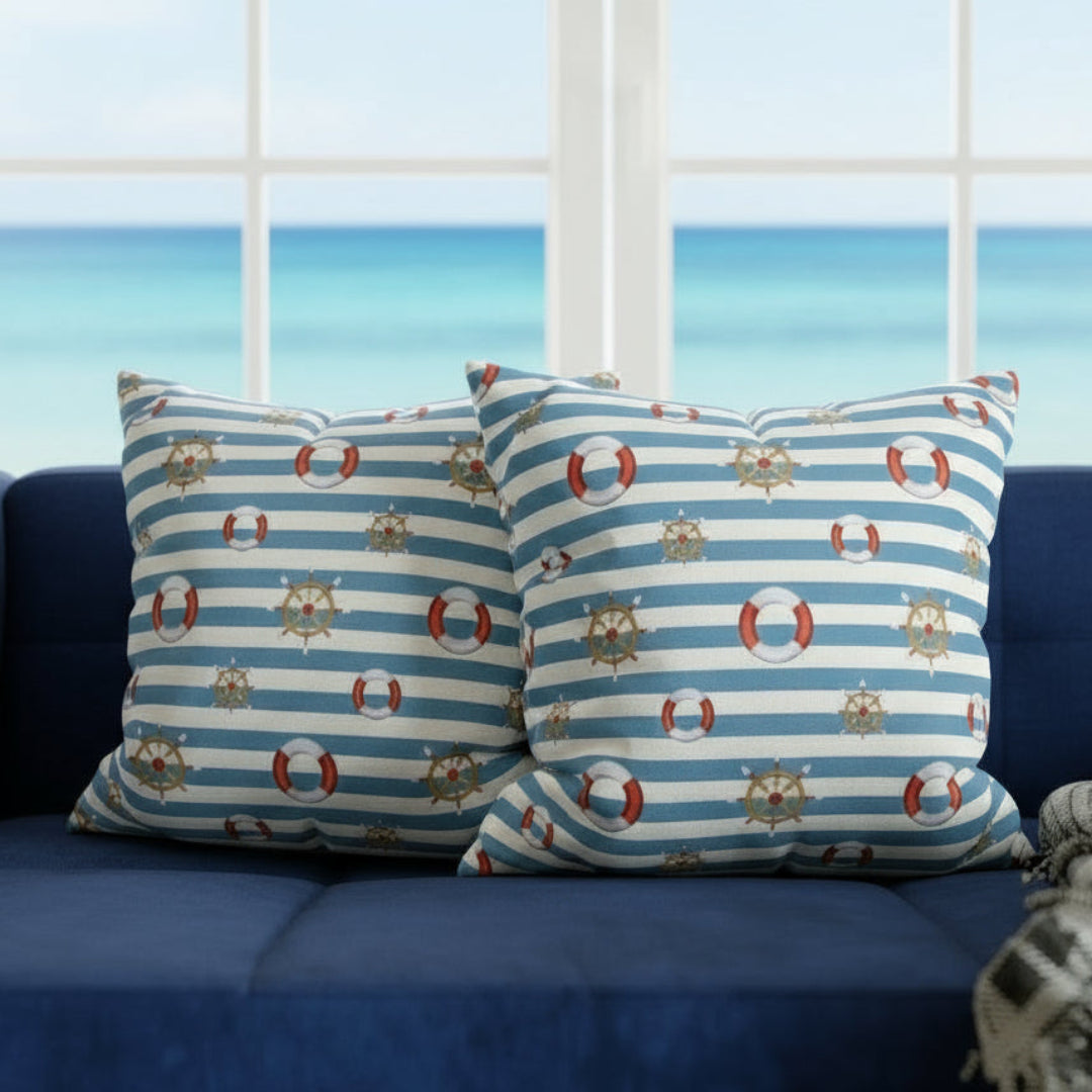 Two decorative pillows with nautical patterns on a gray sofa.