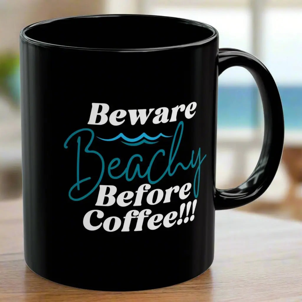 Black coffee mug that says Beware Beachy Before coffee with wave image.