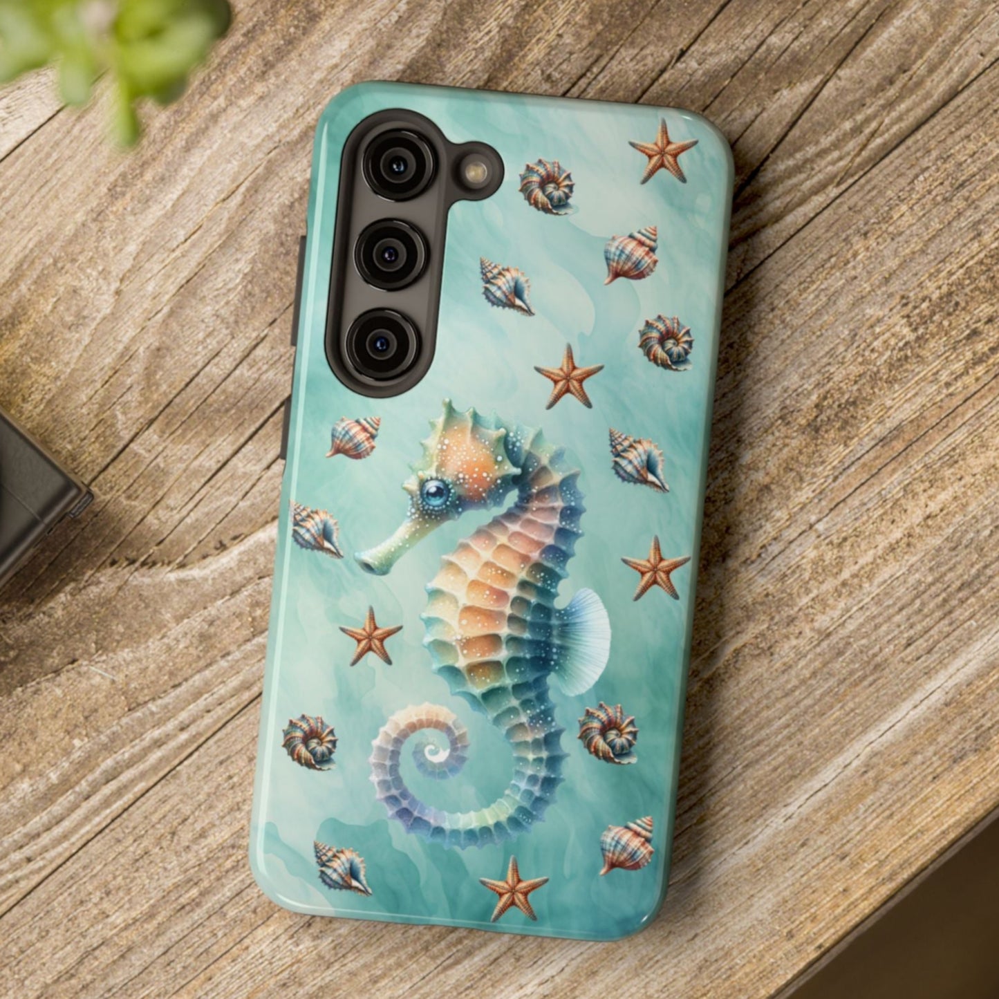Phone case with seahorse design on a wooden surface