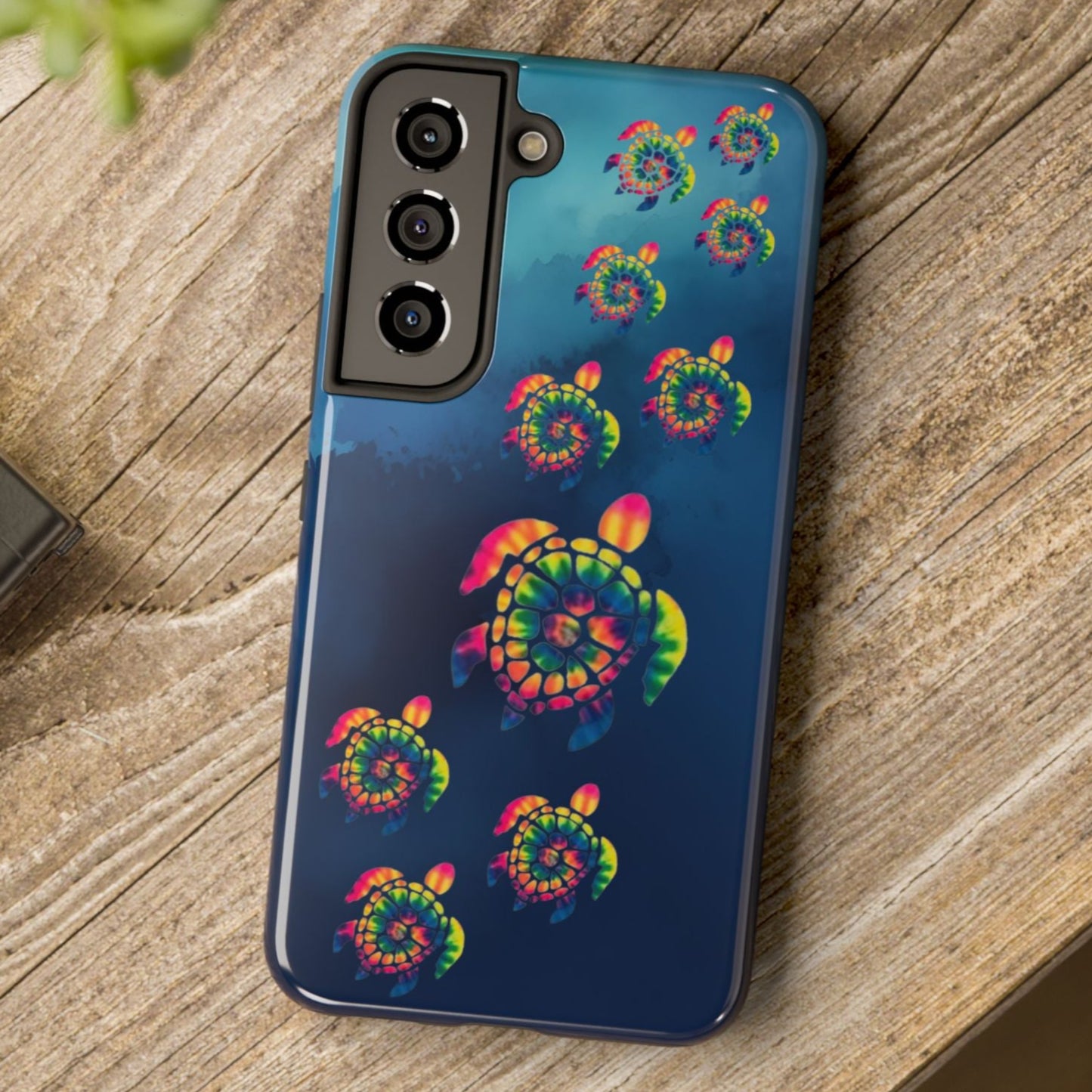 Phone case with colorful spiral design on a wooden surface
