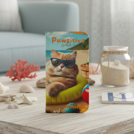 Front view of flip phone case with an illustration of a cat lying in an inner tube on the beach with the text “Pawsitive Vibes,” customizable with a name.