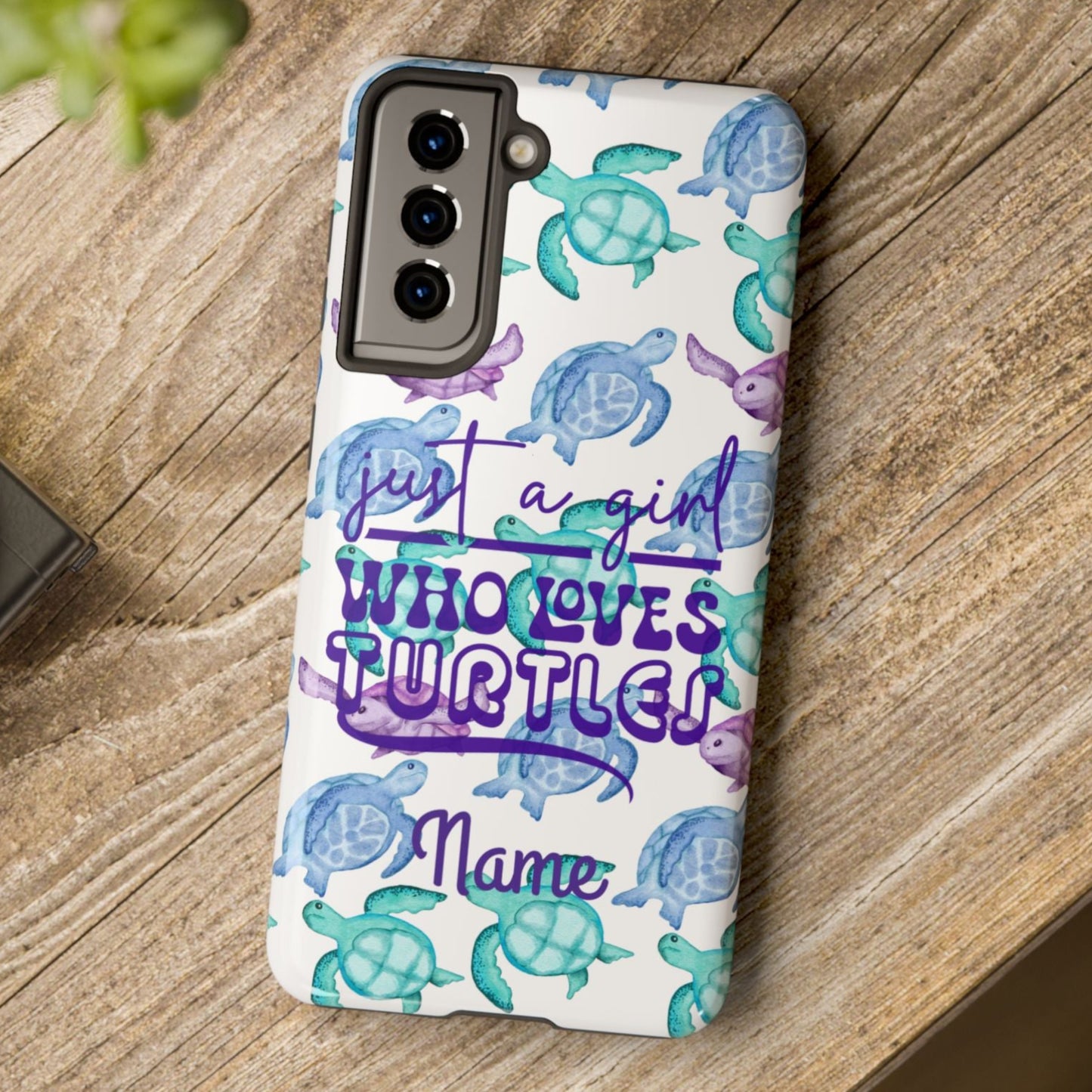 Phone case with sea turtle design and text on a wooden surface