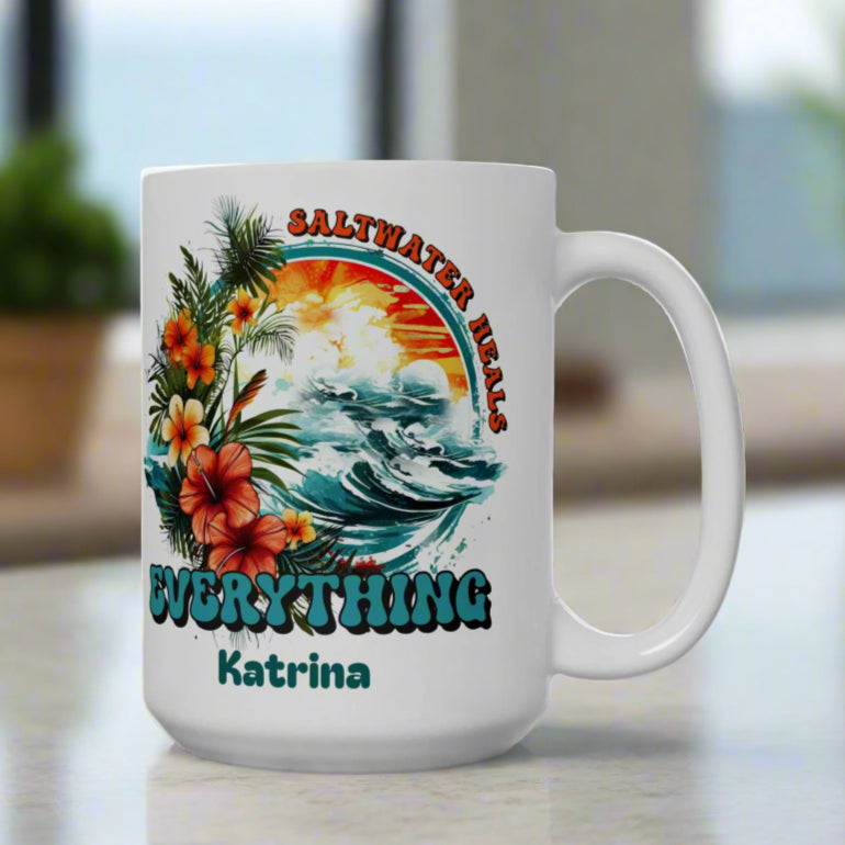 White mug with a colorful design ocean scene that says Saltwater Heals Everything and can be customized with a name.