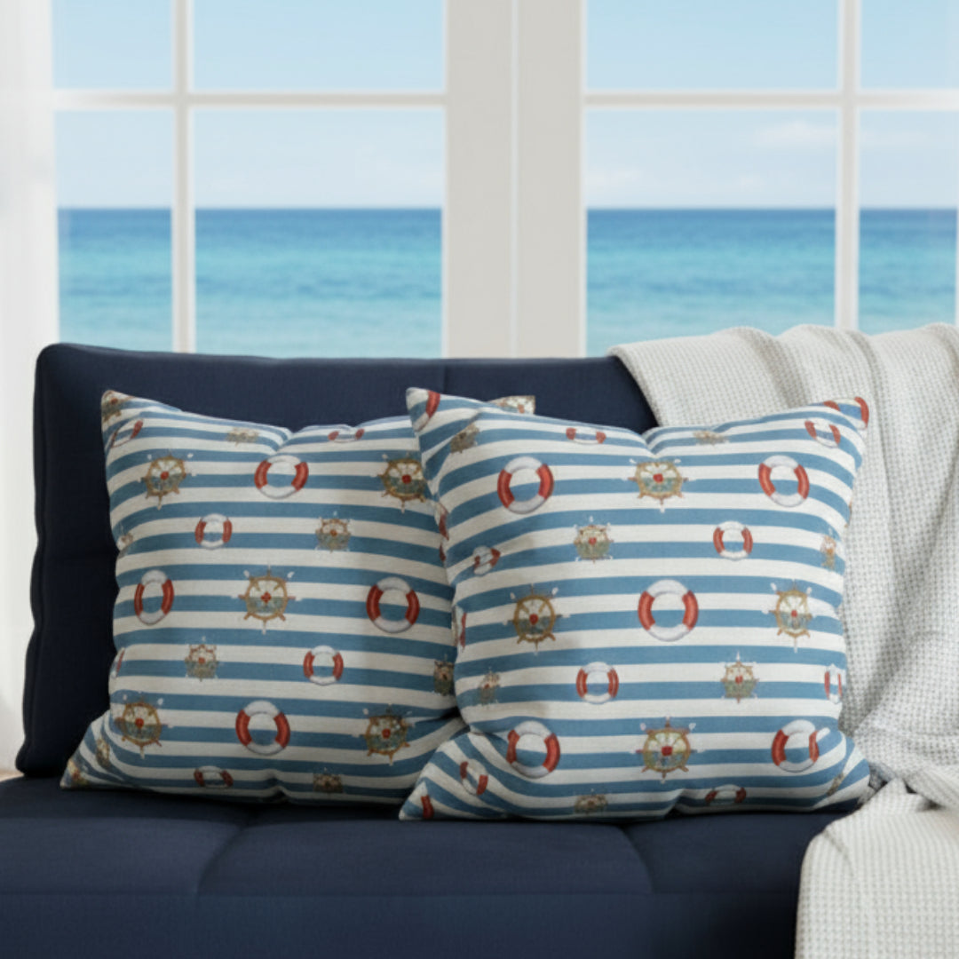 Two decorative pillows with nautical patterns on a gray sofa.