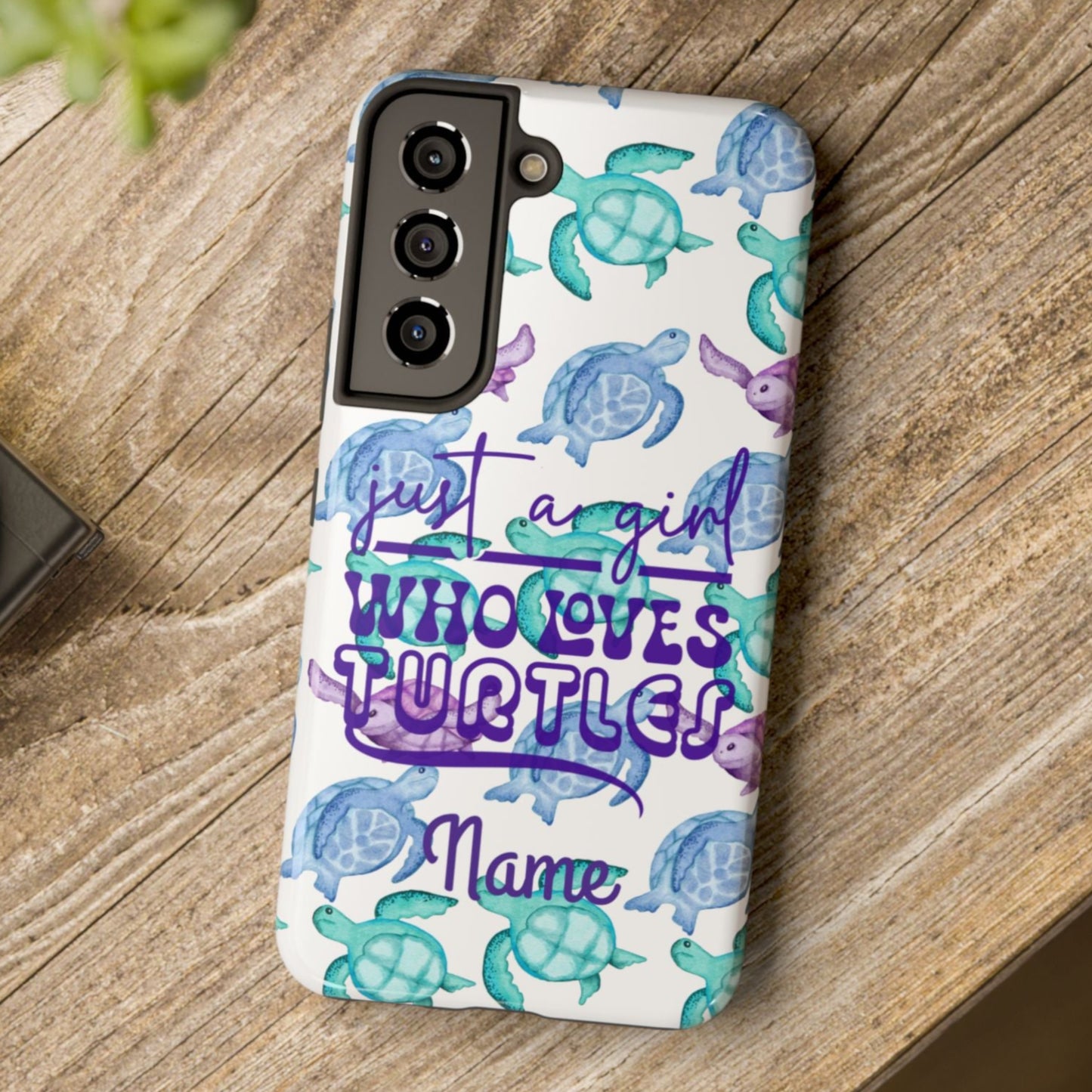 Phone case with sea turtle design and text on a wooden surface