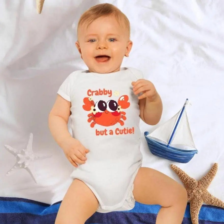 White short sleeved body suit with cartoon crab that says crabby but a cutie.