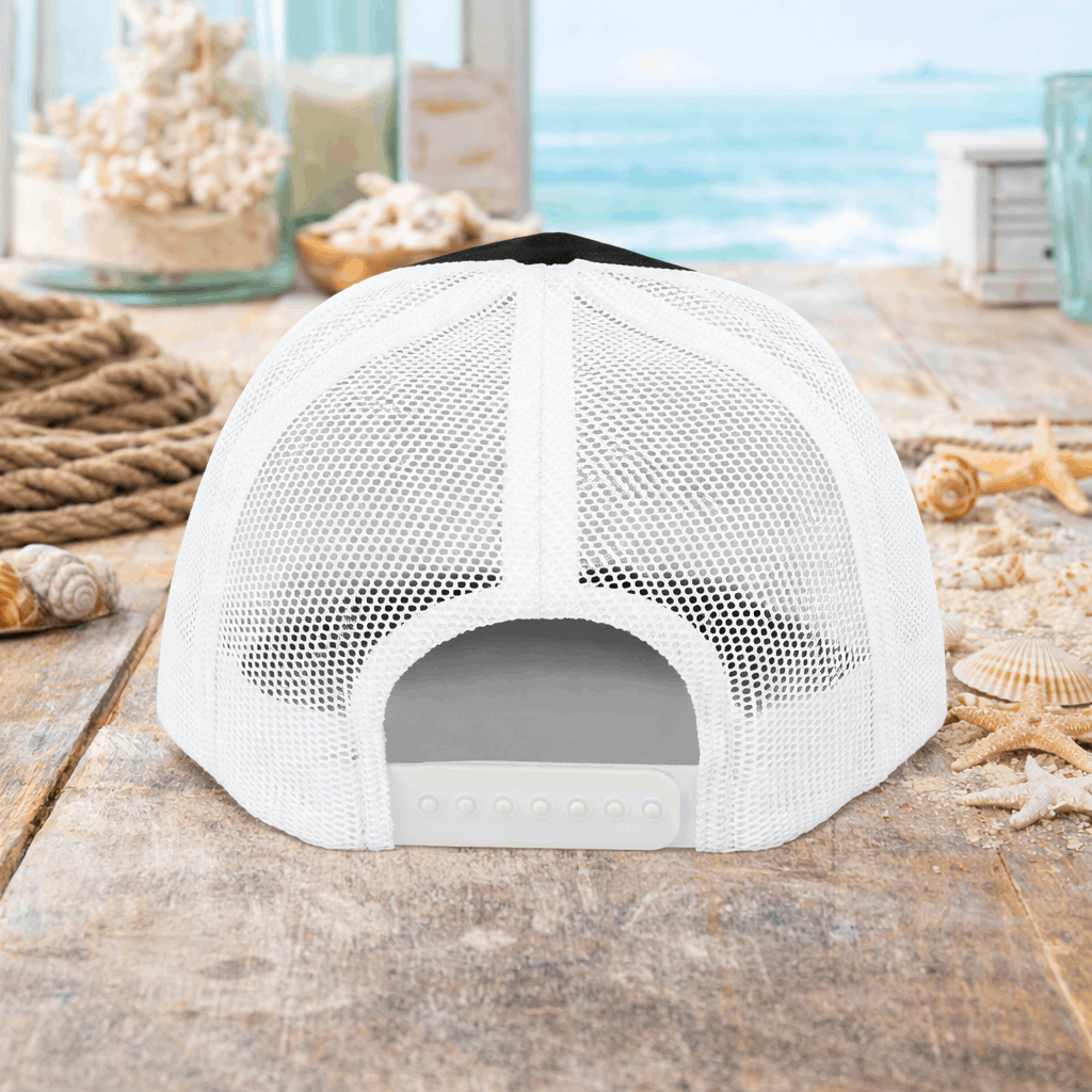 White mesh cap on a wooden surface with a beach-themed background