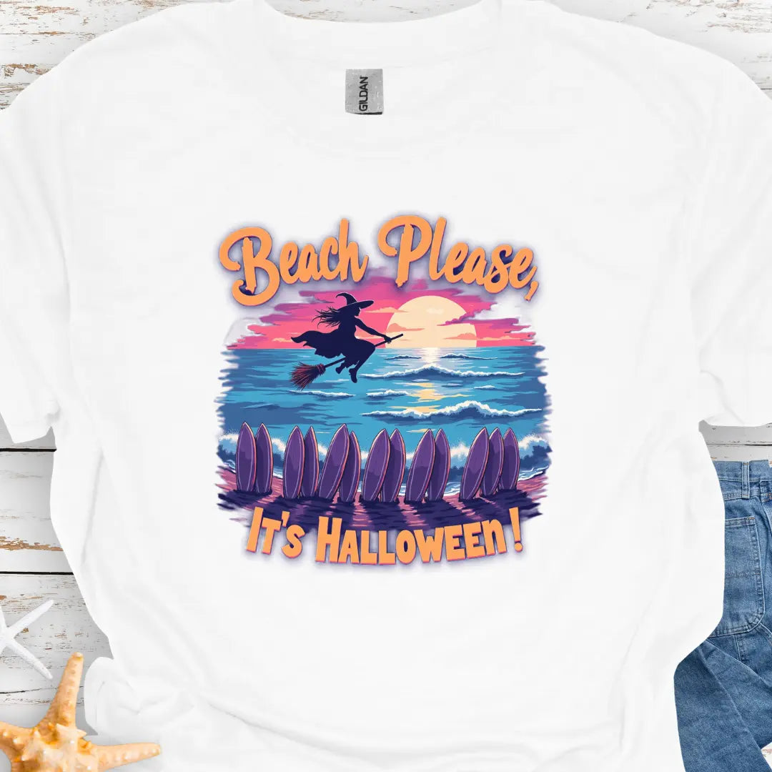 White T-shirt with image of witch flying on a broom over the ocean with surfboards in the sand and text that says Beach Please, It's Halloween.