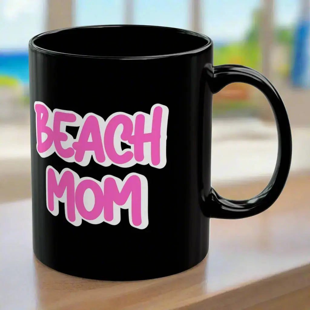 Black 11 oz mug with a bright hot pink with white outline text Beach Mom.