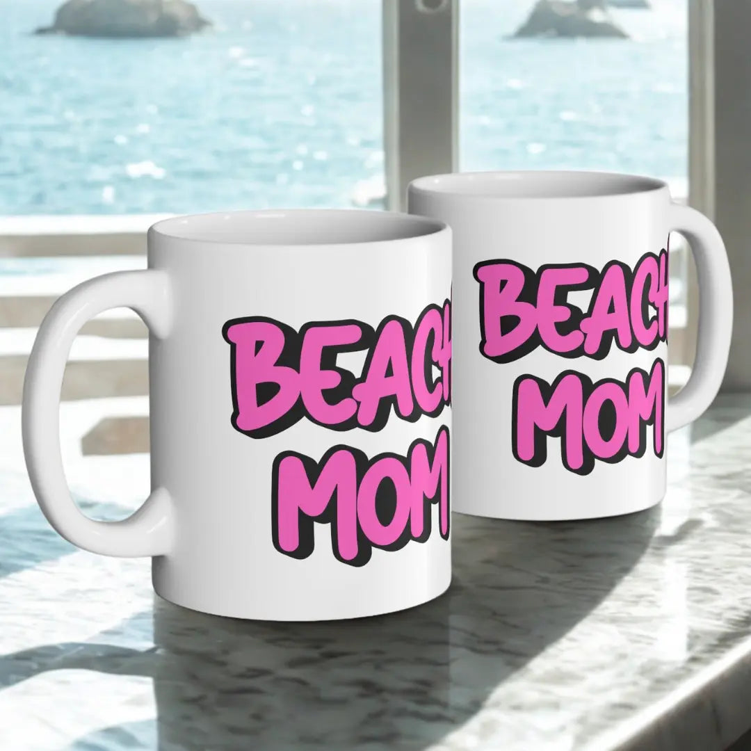 Two White 11 oz mugs with a bright hot pink with black outline text Beach Mom.