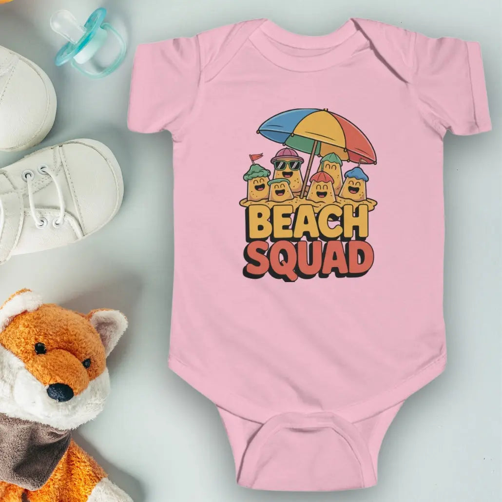 Pink 'Beach Squad' Infant Bodysuit featuring a playful design of sand castle people under a big beach umbrella.