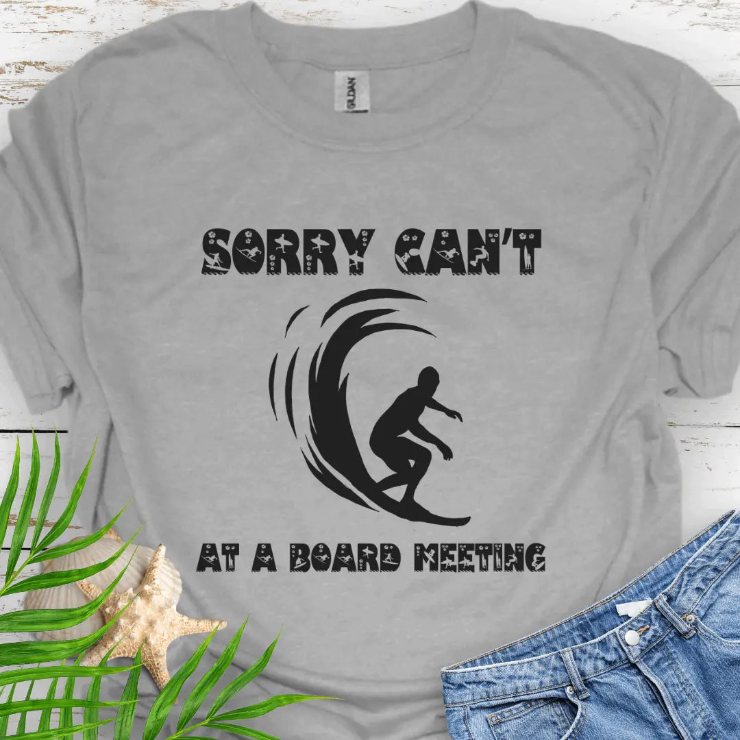 Sport grey t-shirt with a surfer and says Sorry Can't Board Meeting - ideal for beach vacations, casual Fridays, and surfing enthusiasts.