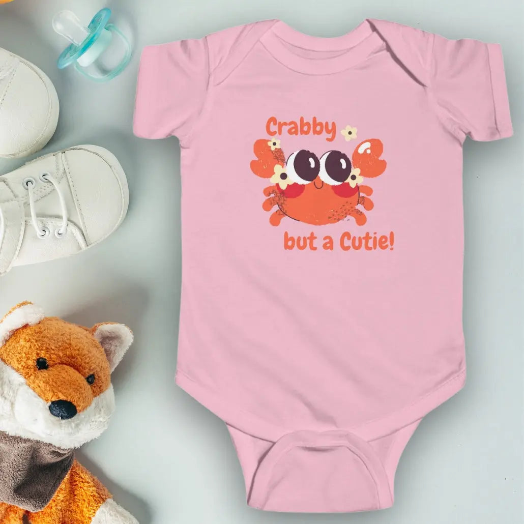 Pink short sleeved body suit with cartoon crab that says crabby but a cutie.
