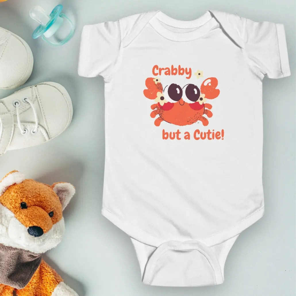 White short sleeved body suit with cartoon crab that says crabby but a cutie.