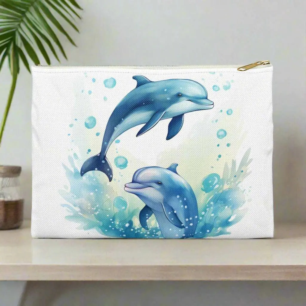 Our Dancing Dolphins Accessory Pouch constructed from a durable material with a zipper closure featuring two dolphins splashing out of the water on a white background. Available in small or large.