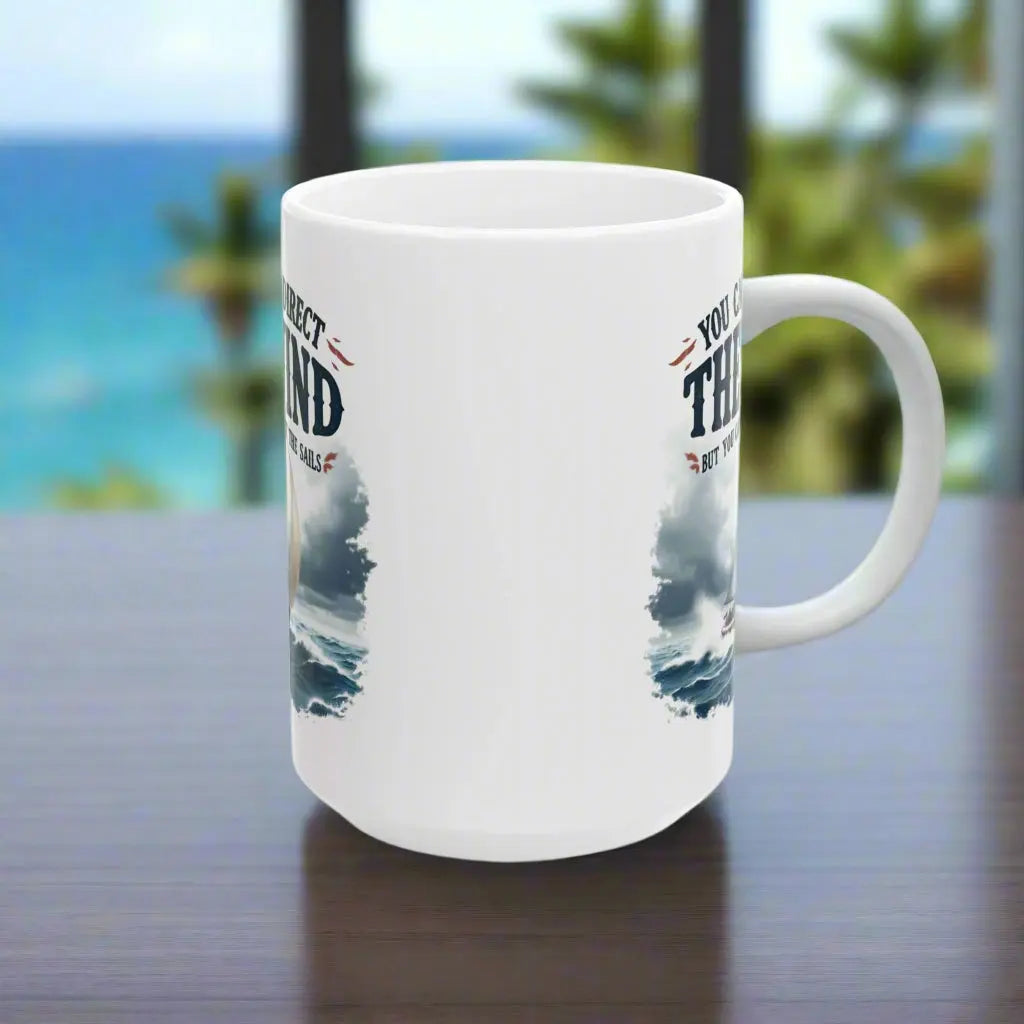 Side view of a white 15 oz. mug with a sailboat on the ocean with text 'You Can't Direct the Wind But You Can Adjust the Sails' with personalized name.