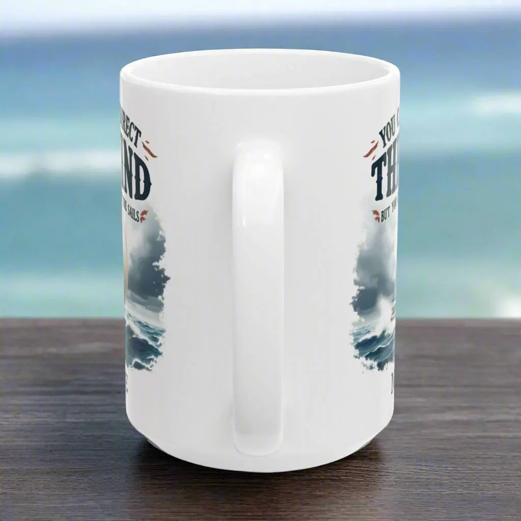 Side view of a white 15 oz. mug with a sailboat on the ocean with text 'You Can't Direct the Wind But You Can Adjust the Sails' with personalized name.