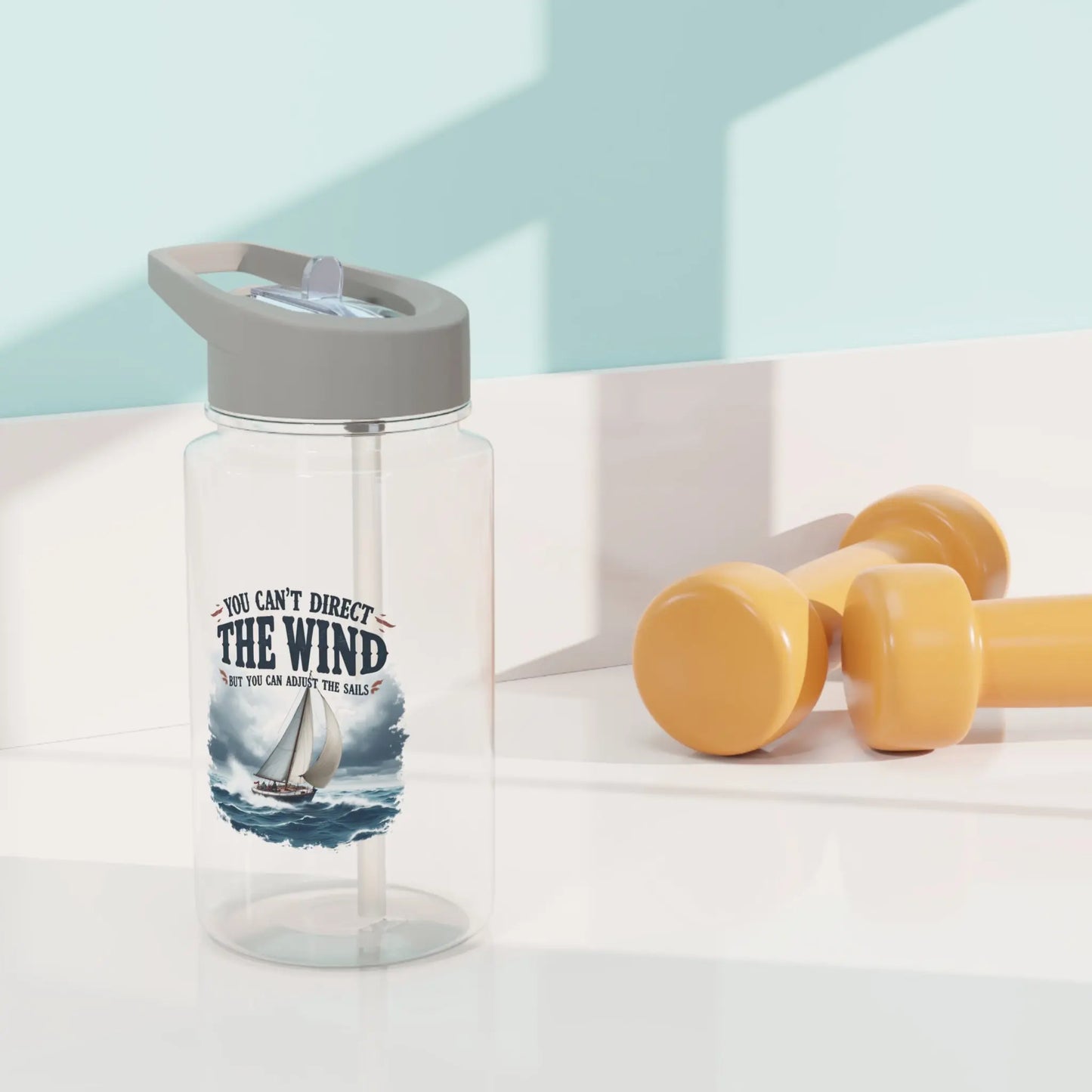 A clear water bottle 11 oz. with a sailboat on the ocean with text 'You Can't Direct the Wind But You Can Adjust the Sails' with personalized name.