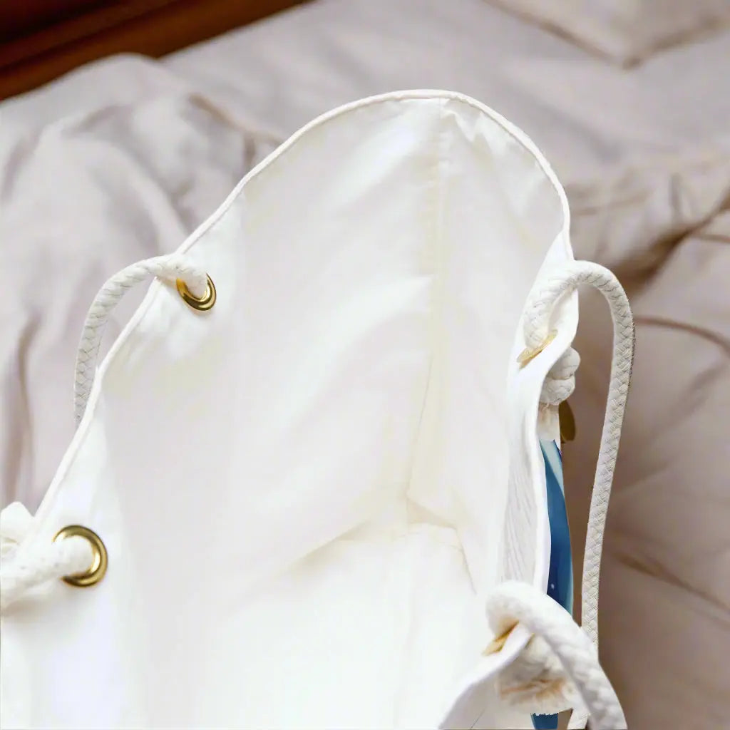 Inside view of our Dolphin Dancer Weekender Bag featuring two dolphins splashing out of the water with a white background. Large bag with durable rope handles help in with gold grommets. Perfect bag for weekend trips, beach bag, and summer vacation!