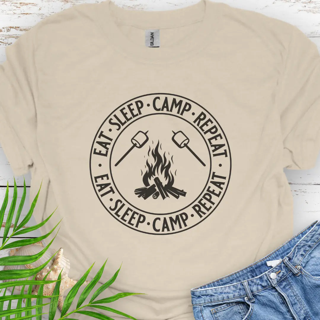 A campfire with two smore sticks that says Eat Sleep Camp Repeat in a circle around the campfire graphic in Natural.