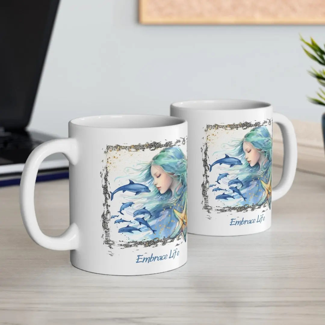 Two White 11 oz Ceramic Mug with a mermaid and swimming dolphins gives a mystical and positive vibe with the text Embrace Life - ideal for those who love the beach and marine life!