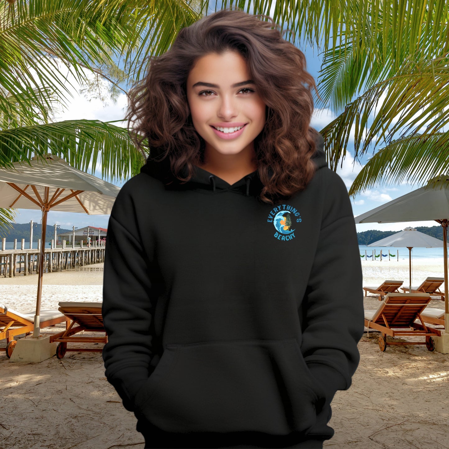 Woman wearing a black Everything’s Beachy logo hoodie with front pocket logo and full back graphic.