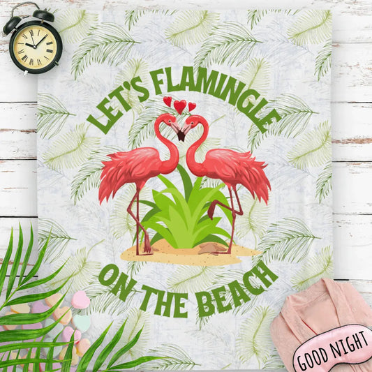 White velveteen plush blanket with green palm fronds and two flamingos in a heart shape that says Let's Flamingle. -perfect for snuggling on cold nights or as a comforting gift for a loved one who is a beach lover.