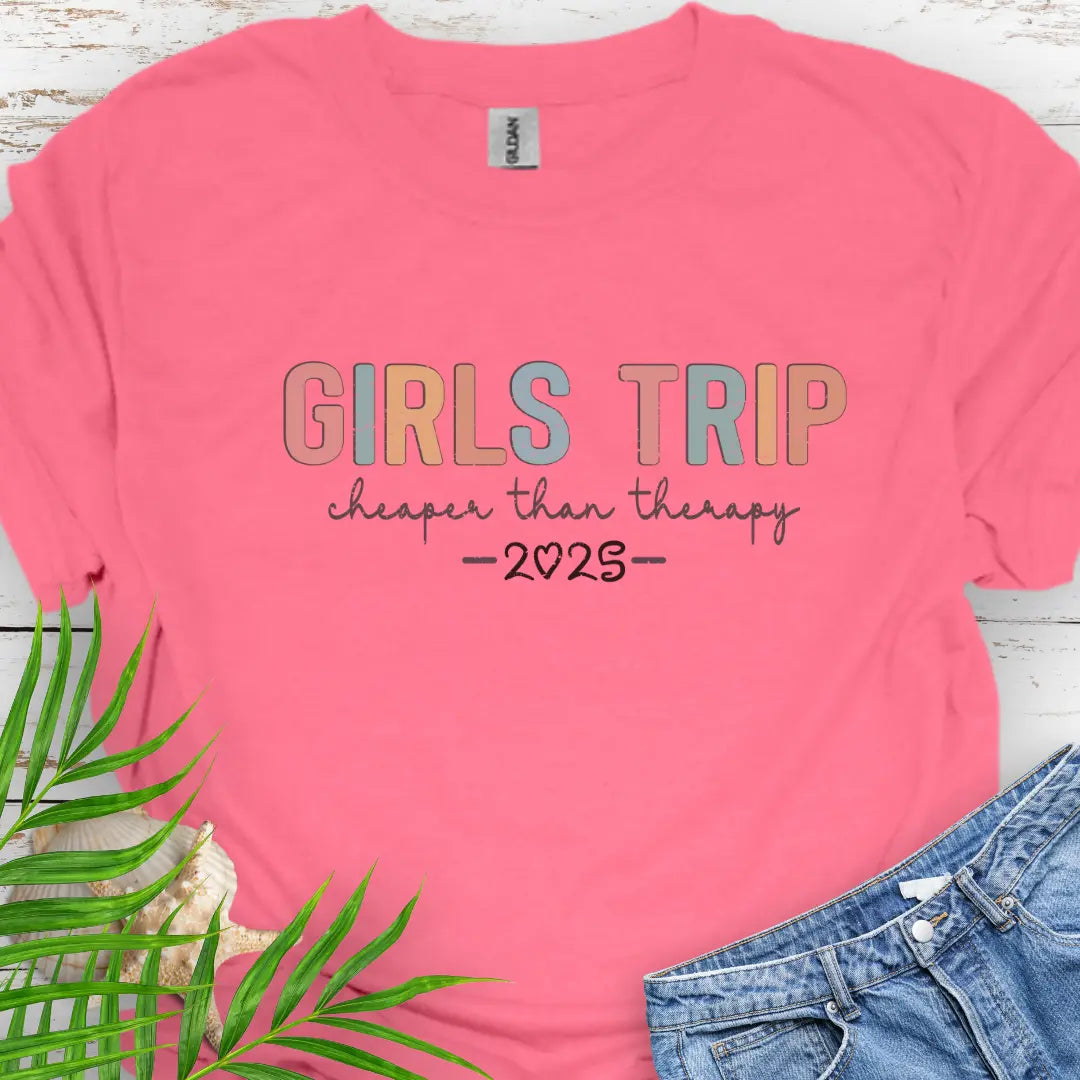 Coral Silk Girl’s Trip T-shirt with colorful grunge text, "Cheaper Than Therapy," and a customizable year. Perfect for group trips, fun getaways, and lasting memories.