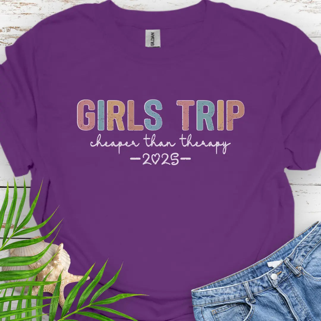 Purple Girl’s Trip T-shirt with colorful grunge text, "Cheaper Than Therapy," and a customizable year. Perfect for group trips, fun getaways, and lasting memories.