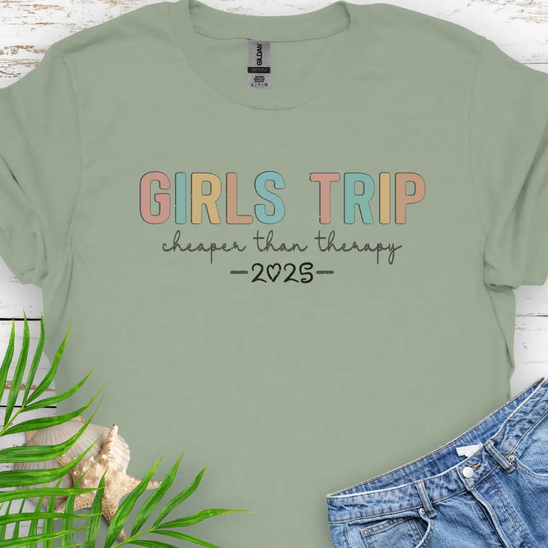 Sage Girl’s Trip T-shirt with colorful grunge text, "Cheaper Than Therapy," and a customizable year. Perfect for group trips, fun getaways, and lasting memories.