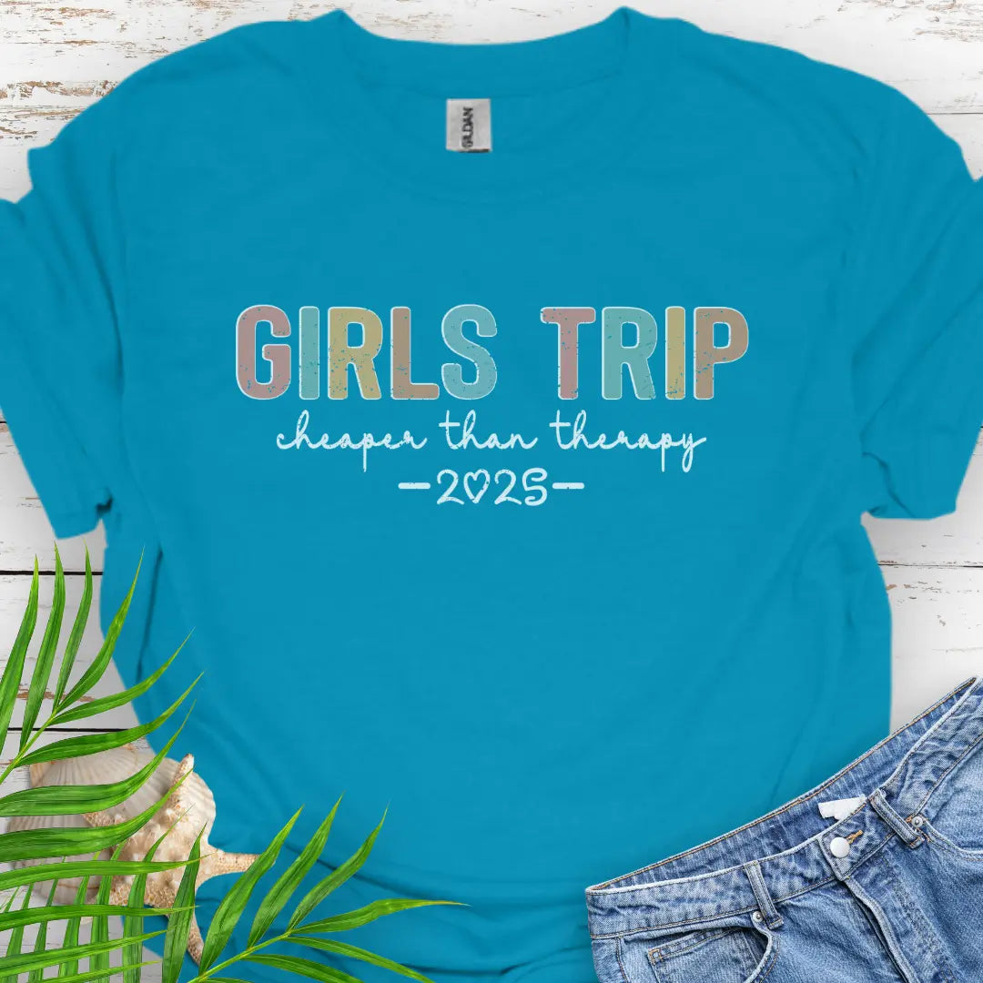 Tropical Blue Girl’s Trip T-shirt with colorful grunge text, "Cheaper Than Therapy," and a customizable year. Perfect for group trips, fun getaways, and lasting memories.