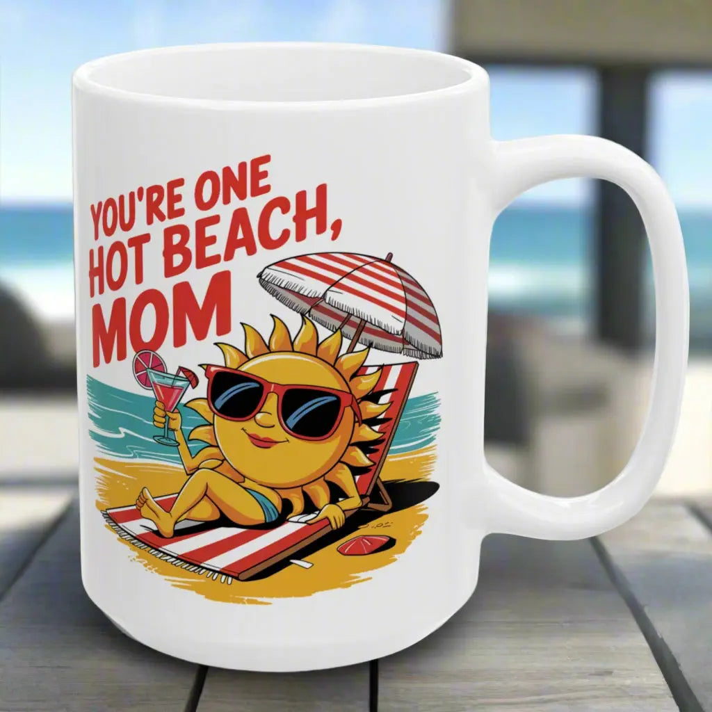 A white 15 oz mug with a sexy sun laying on a beach towel holding a drink on the beach that says You're One Hot Beach Mom.