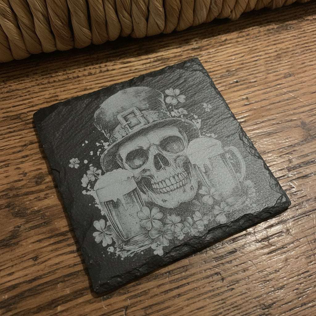 Slate coaster with a skull design holding beer mugs and shamrocks on a woven basket background.