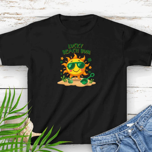 Lucky Beach Bum Child's Black small T-shirt with a smiling sun wearing green sunglasses on the beach with beach toys.