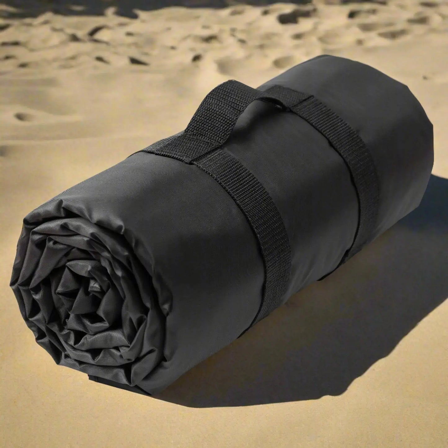 Rolled up beach blanket showing the handle for carrying.