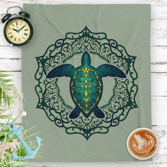 Our plush velveteen blanket in sage with a sea turtle and a fancy mandala frame in emerald green.
