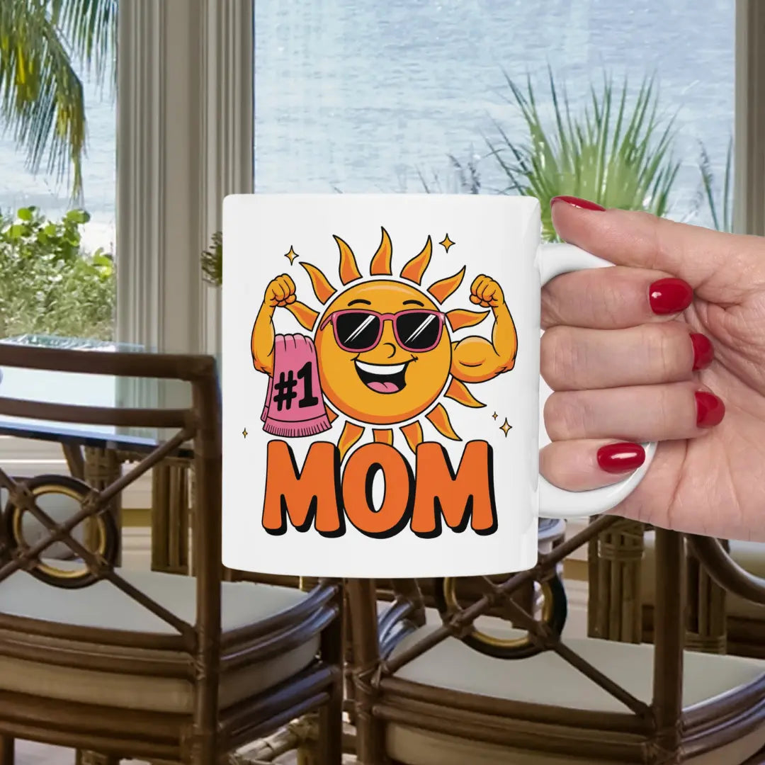 A white 11 oz mug with a muscle woman sun wearing sunglasses holding a beach towel over her arm that says #1 Mom.