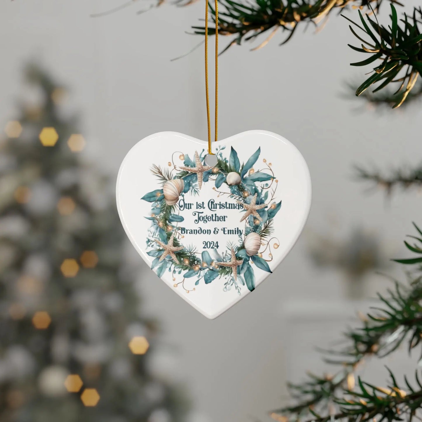 White heart ornament featuring a beach-themed wreath with seashells and starfish, displaying "Our 1st Christmas Together." Personalized with names and year, this coastal holiday keepsake is perfect for celebrating a special first Christmas.
