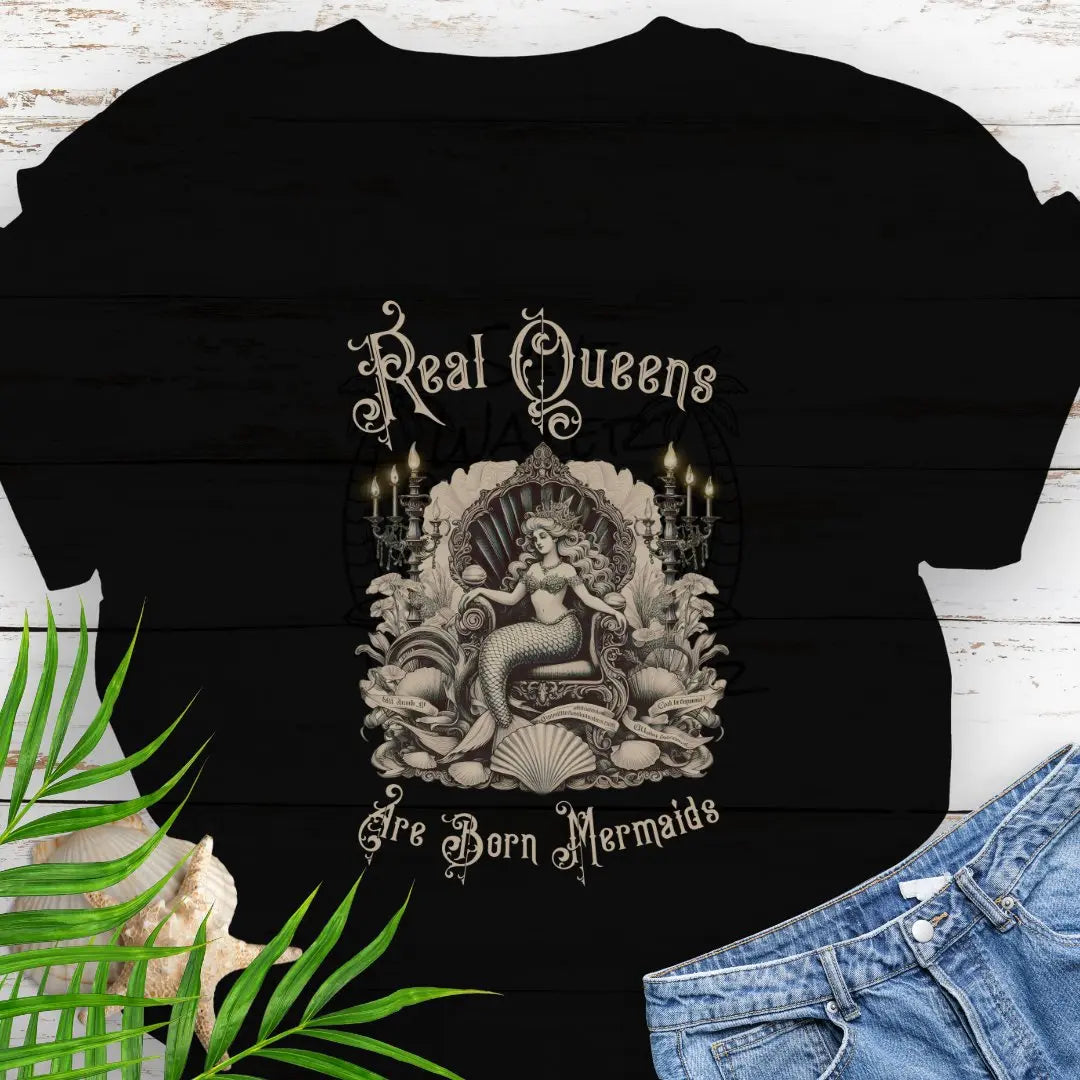 Black T-shirt with mermaid in Victorian style chair and surrounding shells and candles with the text Real Queens Are Born Mermaids -perfect for those who believe in mermaid magic and want to showcase their inner queen.