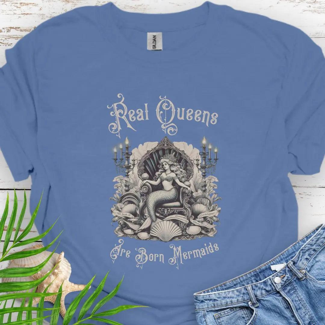 Indigo blue T-shirt with mermaid in Victorian style chair and surrounding shells and candles with the text Real Queens Are Born Mermaids -perfect for those who believe in mermaid magic and want to showcase their inner queen.