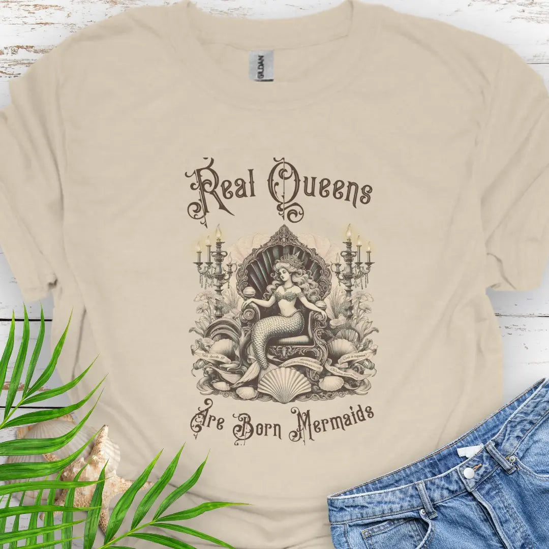 Natural T-shirt with mermaid in Victorian style chair and surrounding shells and candles with the text Real Queens Are Born Mermaids -perfect for those who believe in mermaid magic and want to showcase their inner queen.