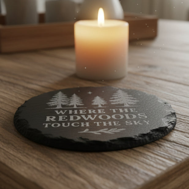 Black slate stone with engraved trees and text Where the Redwoods Touch the Sky.