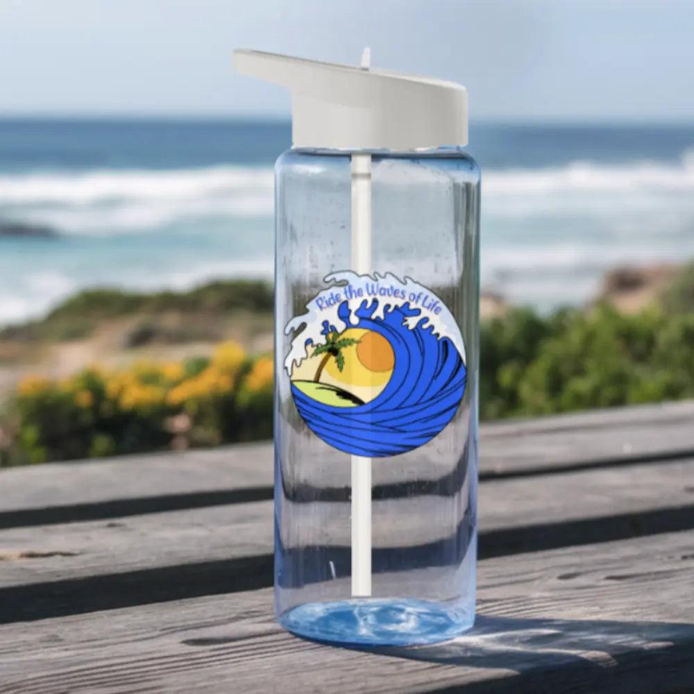 Clear water bottle with blue waves, yellow sun, palm trees, and birds sitting on a picnic table at the beach.